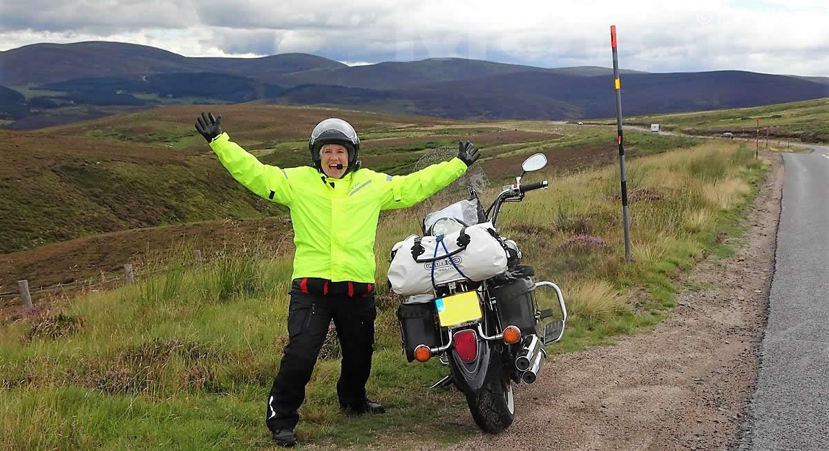 Happy Biking Women mit ein Reisemotor während einer Motorradtour durch Schottland